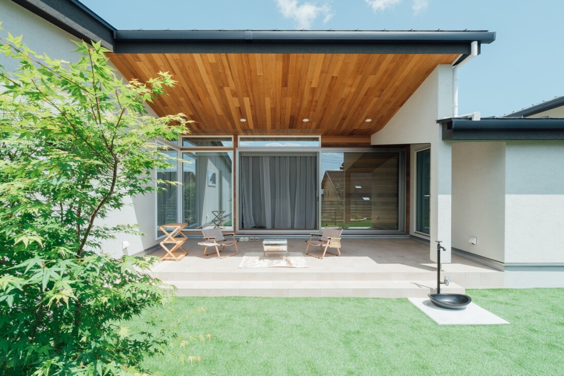木の軒天と中庭テラス・芝庭のある平屋の外観